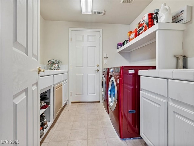 6639 Tranquil Seas Ct, Las Vegas, NV 89139 - laundry area featuring washing machine and clothes dryer, cabinet space, and light tile patterned floors