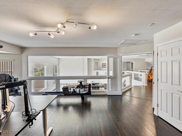 6639 Tranquil Seas Ct, Las Vegas, NV 89139 - exercise room with dark wood-style flooring, attic access, and a textured ceiling