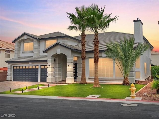6639 Tranquil Seas Ct, Las Vegas, NV 89139 - view of front of home with a garage, a lawn, a tile roof, driveway, and stucco siding