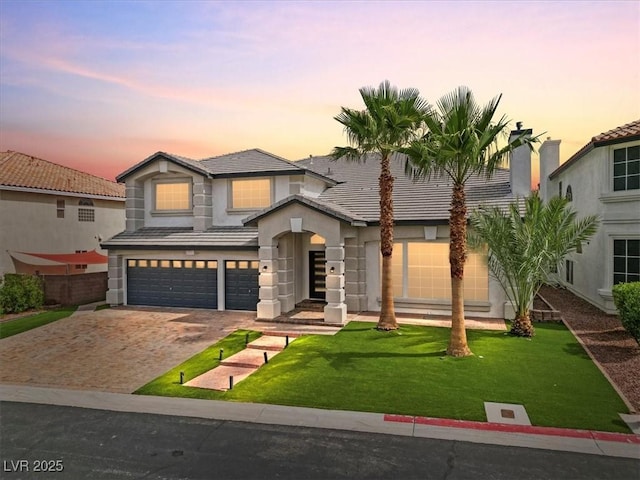6639 Tranquil Seas Ct, Las Vegas, NV 89139 - view of front of property featuring an attached garage, a lawn, driveway, stucco siding, and a tiled roof