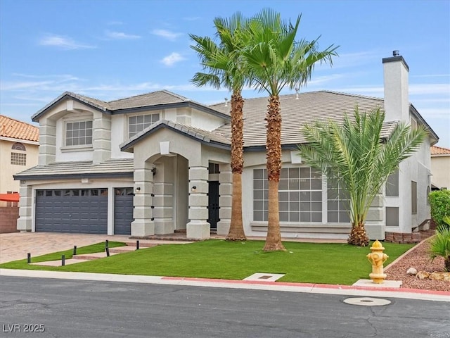 6639 Tranquil Seas Ct, Las Vegas, NV 89139 - view of front facade featuring an attached garage, a tile roof, a front lawn, driveway, and a chimney