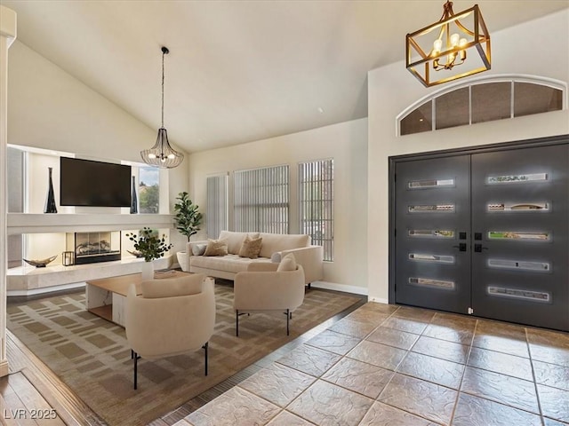 6639 Tranquil Seas Ct, Las Vegas, NV 89139 - foyer entrance featuring a chandelier, high vaulted ceiling, baseboards, and a tile fireplace