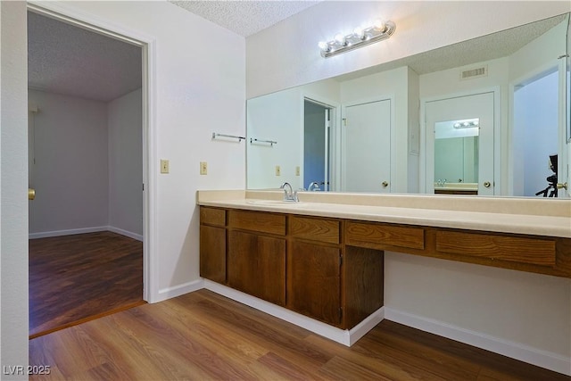 3811 Desert Marina Dr Unit 125, Laughlin, NV 89029 - bathroom with a textured ceiling, wood finished floors, vanity, and baseboards