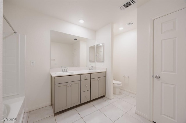 5927 Coja St, Las Vegas, NV 89113 - bathroom featuring double vanity, tile patterned floors, a tub to relax in, toilet, and recessed lighting