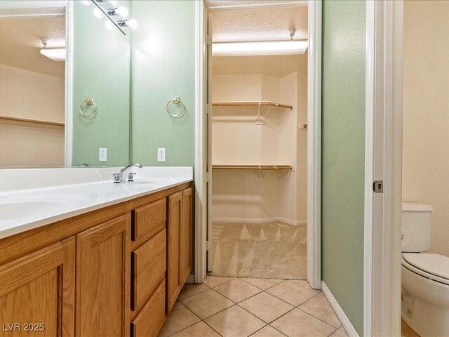 38 E Serene Ave Unit 134, Las Vegas, NV 89123 - full bathroom featuring toilet, double vanity, tile patterned floors, a spacious closet, and baseboards