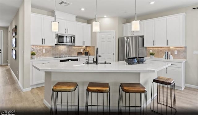 2615 Regency Cove Ct Lot 13, Las Vegas, NV 89121 - kitchen with appliances with stainless steel finishes, a sink, light wood-type flooring, a kitchen bar, and recessed lighting