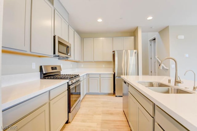 11840 Pelican Butte Ave, Las Vegas, NV 89138 - kitchen featuring appliances with stainless steel finishes, a sink, light countertops, recessed lighting, and light wood-type flooring