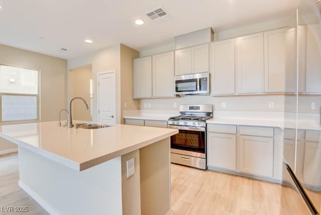 11840 Pelican Butte Ave, Las Vegas, NV 89138 - kitchen with appliances with stainless steel finishes, a sink, an island with sink, recessed lighting, and light countertops