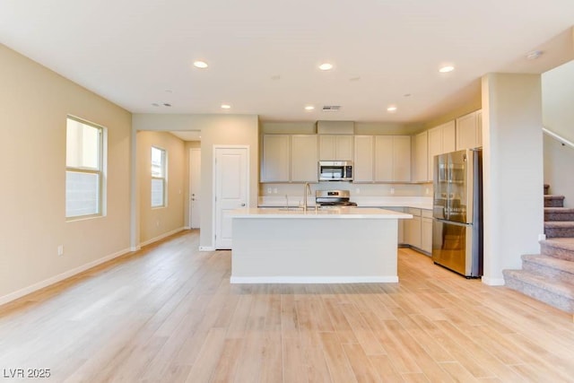 11840 Pelican Butte Ave, Las Vegas, NV 89138 - kitchen with appliances with stainless steel finishes, light countertops, light wood-style flooring, a kitchen island with sink, and a sink