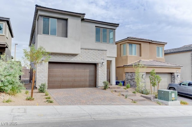11840 Pelican Butte Ave, Las Vegas, NV 89138 - view of front facade featuring stucco siding, a garage, stone siding, and decorative driveway