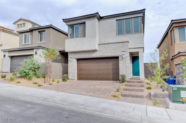 11840 Pelican Butte Ave, Las Vegas, NV 89138 - modern home featuring stucco siding, a garage, stone siding, and decorative driveway