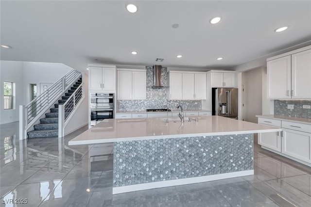 1038 Delbrook Ave, Henderson, NV 89012 - kitchen with appliances with stainless steel finishes, wall chimney exhaust hood, a large island with sink, a sink, and decorative backsplash