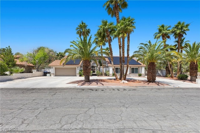 2250 Bowie Cir, Henderson, NV 89014 - view of front of home with roof mounted solar panels, driveway, a garage, stucco siding, and a tile roof