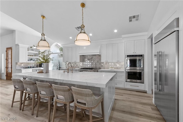 2250 Bowie Cir, Henderson, NV 89014 - kitchen with stainless steel appliances, a sink, backsplash, open shelves, and white cabinetry