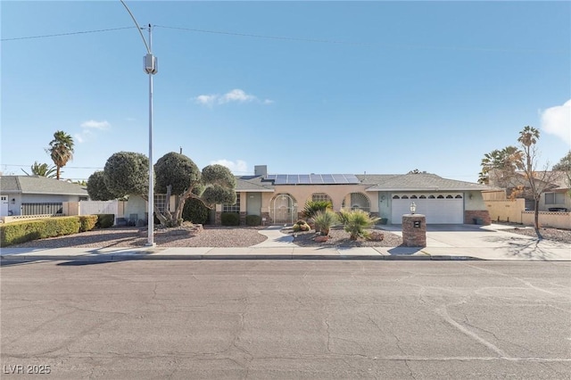 1912 Parkchester Dr, Las Vegas, NV 89108 - view of front of home with roof mounted solar panels, concrete driveway, an attached garage, and stucco siding