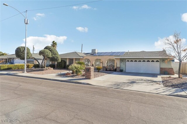 1912 Parkchester Dr, Las Vegas, NV 89108 - ranch-style house with solar panels, a garage, driveway, and stucco siding