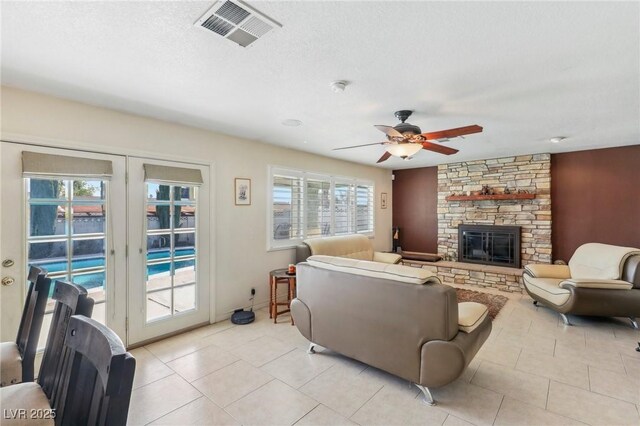 1912 Parkchester Dr, Las Vegas, NV 89108 - living room featuring a stone fireplace, a ceiling fan, and light tile patterned floors