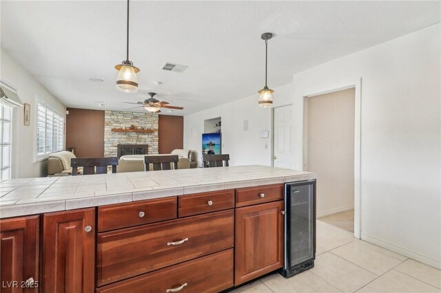 1912 Parkchester Dr, Las Vegas, NV 89108 - kitchen featuring wine cooler, ceiling fan, tile countertops, and a stone fireplace