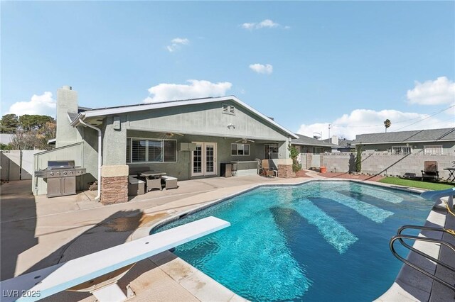 1912 Parkchester Dr, Las Vegas, NV 89108 - view of swimming pool with area for grilling, a diving board, a fenced backyard, and a patio area