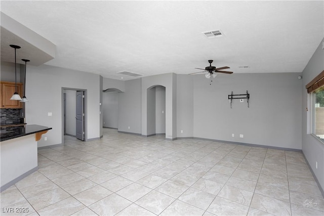 854 Santa Maria Way, Mesquite, NV 89027 - unfurnished living room featuring ceiling fan, arched walkways, light tile patterned floors, and baseboards