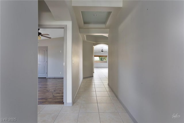 854 Santa Maria Way, Mesquite, NV 89027 - corridor featuring light tile patterned floors, baseboards, a tray ceiling, and arched walkways