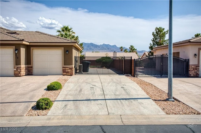 854 Santa Maria Way, Mesquite, NV 89027 - view of side of property with a gate, stone siding, concrete driveway, stucco siding, and a mountain view