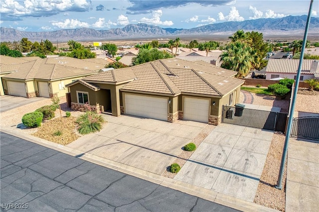 854 Santa Maria Way, Mesquite, NV 89027 - view of front of property with stucco siding, a gate, a mountain view, a tiled roof, and stone siding