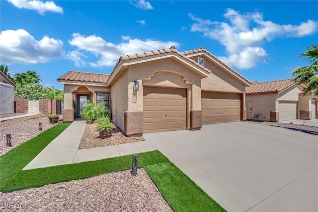 2558 Wiltshire Ave, Henderson, NV 89052 - mediterranean / spanish house featuring an attached garage, stucco siding, a tile roof, and driveway