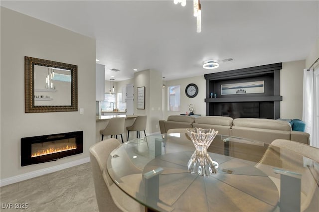 2558 Wiltshire Ave, Henderson, NV 89052 - dining space with a glass covered fireplace and baseboards