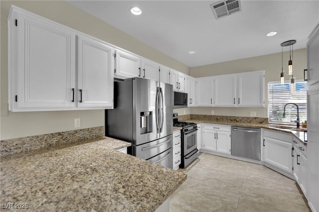 2558 Wiltshire Ave, Henderson, NV 89052 - kitchen with stainless steel appliances, a sink, light stone countertops, white cabinetry, and pendant lighting
