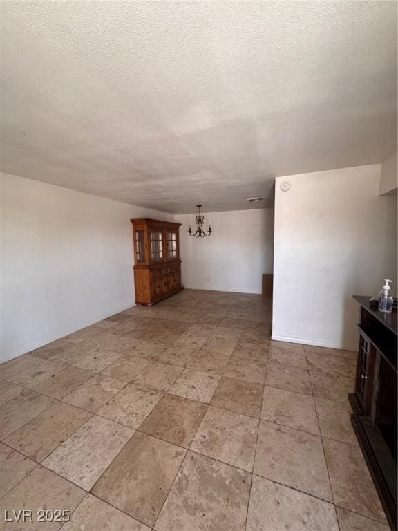 2604 Webster St, North Las Vegas, NV 89030 - unfurnished living room featuring a chandelier, a textured ceiling, and light tile patterned flooring