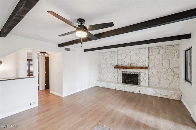 1251 Los Meadows Dr, Las Vegas, NV 89110 - unfurnished living room with beam ceiling, a ceiling fan, wood finished floors, and a fireplace