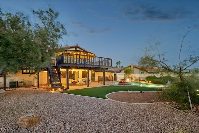 1251 Los Meadows Dr, Las Vegas, NV 89110 - rear view of house with stairs, a wooden deck, a fenced backyard, a patio area, and stucco siding