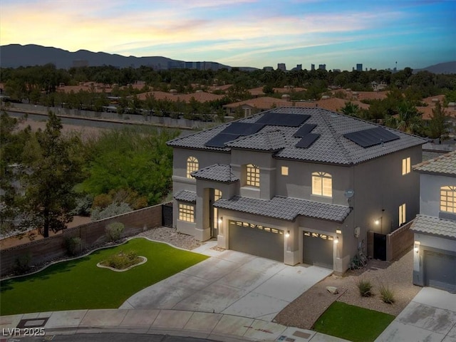 3204 Rutledge Dr, Las Vegas, NV 89120 - mediterranean / spanish house featuring stucco siding, a garage, solar panels, a tiled roof, and concrete driveway