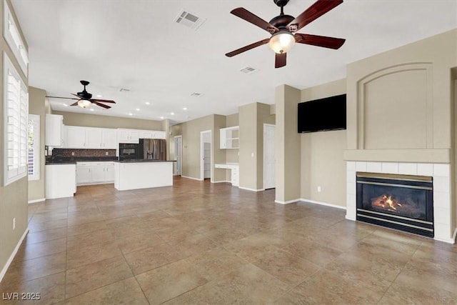 3204 Rutledge Dr, Las Vegas, NV 89120 - unfurnished living room featuring a ceiling fan, a tiled fireplace, and baseboards