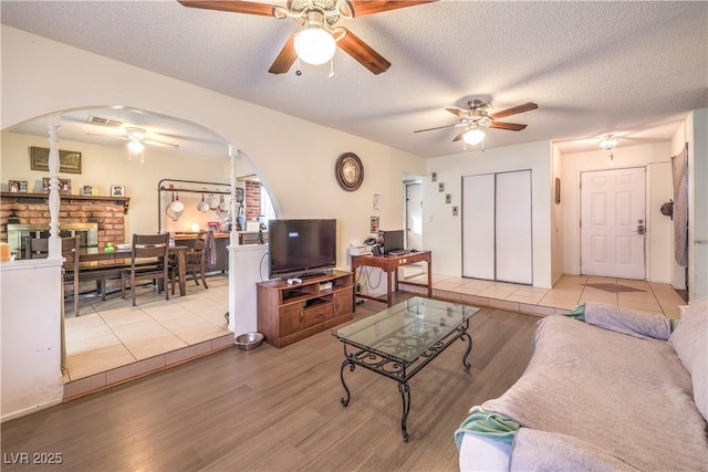 5809 Robin Ln, Las Vegas, NV 89108 - living area with a ceiling fan, arched walkways, wood finished floors, ornate columns, and a textured ceiling