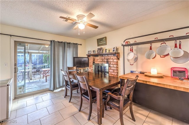 5809 Robin Ln, Las Vegas, NV 89108 - dining room with ceiling fan, a textured ceiling, light tile patterned floors, and a fireplace