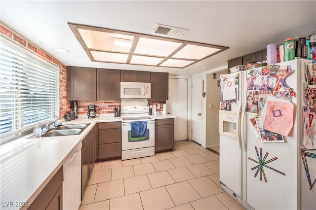 5809 Robin Ln, Las Vegas, NV 89108 - kitchen featuring white appliances, a sink, light countertops, dark brown cabinets, and light tile patterned flooring