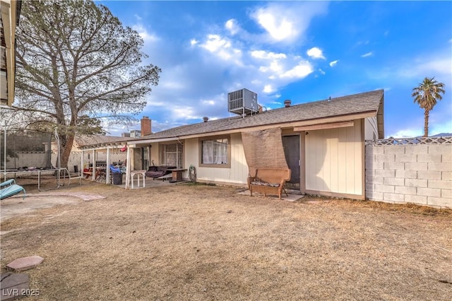 5809 Robin Ln, Las Vegas, NV 89108 - rear view of property with a trampoline, central AC unit, roof with shingles, and a patio