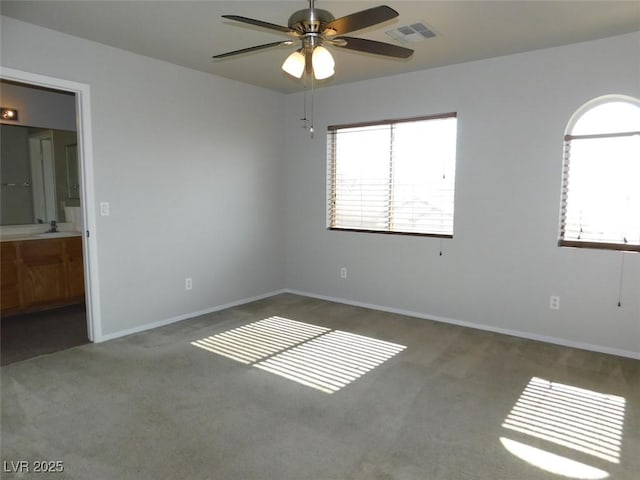 2905 Shimmering Bay St, Laughlin, NV 89029 - unfurnished bedroom featuring carpet floors, multiple windows, connected bathroom, and baseboards