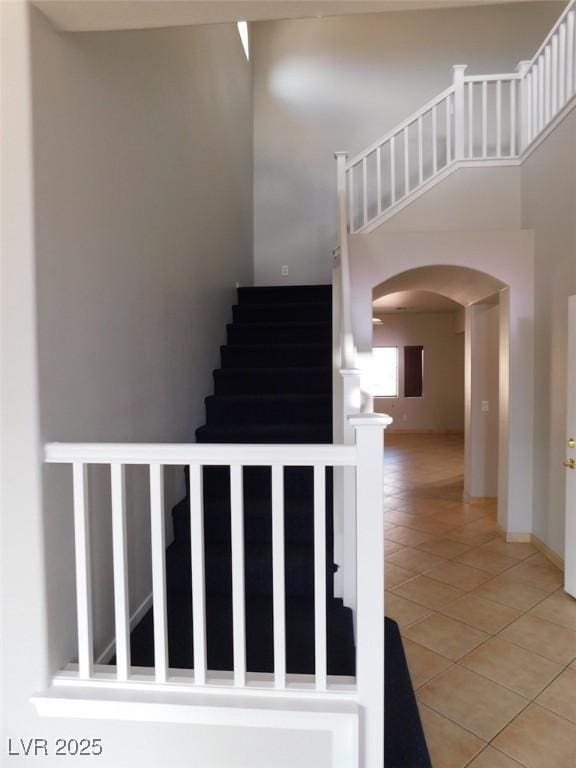 2905 Shimmering Bay St, Laughlin, NV 89029 - stairway featuring arched walkways, tile patterned flooring, and a high ceiling