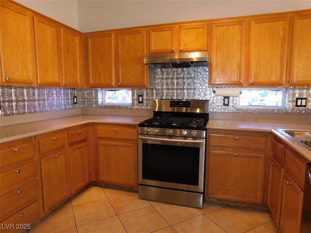 2905 Shimmering Bay St, Laughlin, NV 89029 - kitchen with gas stove, under cabinet range hood, light tile patterned floors, and light countertops