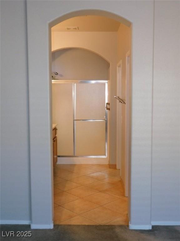 2905 Shimmering Bay St, Laughlin, NV 89029 - hall featuring light tile patterned flooring, arched walkways, and baseboards