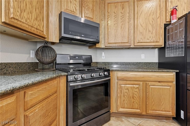 10329 Walworth Ave, Las Vegas, NV 89166 - kitchen with stainless steel appliances, light tile patterned floors, and dark stone countertops