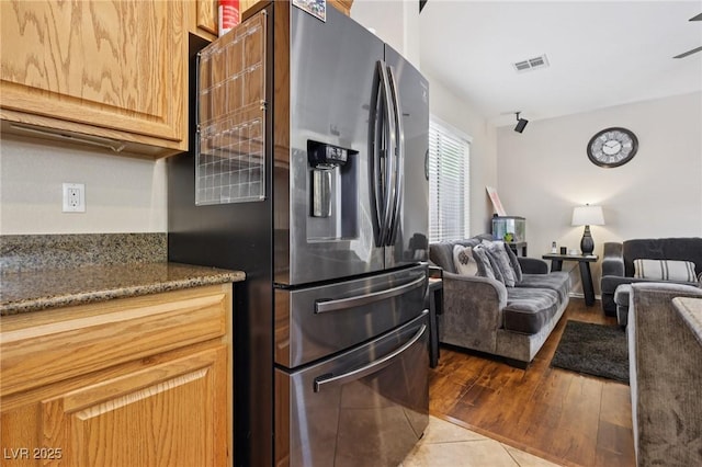 10329 Walworth Ave, Las Vegas, NV 89166 - kitchen featuring stainless steel fridge, wood finished floors, dark stone countertops, and open floor plan