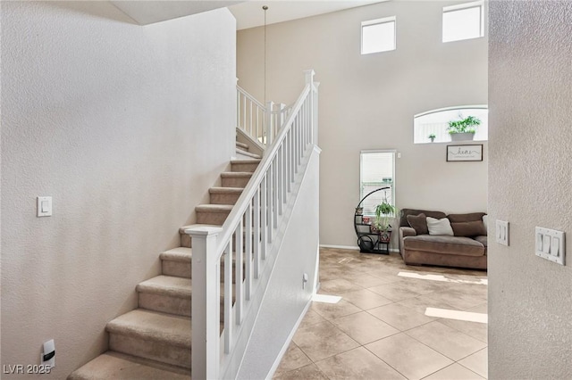 10329 Walworth Ave, Las Vegas, NV 89166 - stairway featuring a high ceiling, tile patterned floors, and a textured wall