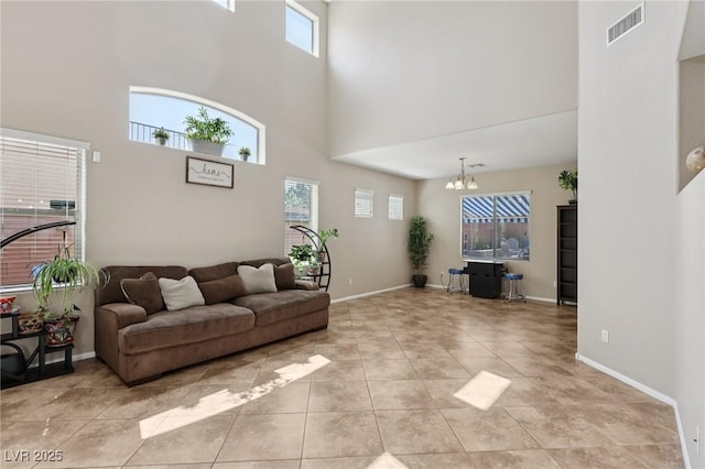 10329 Walworth Ave, Las Vegas, NV 89166 - living room with a towering ceiling, a chandelier, light tile patterned flooring, and baseboards