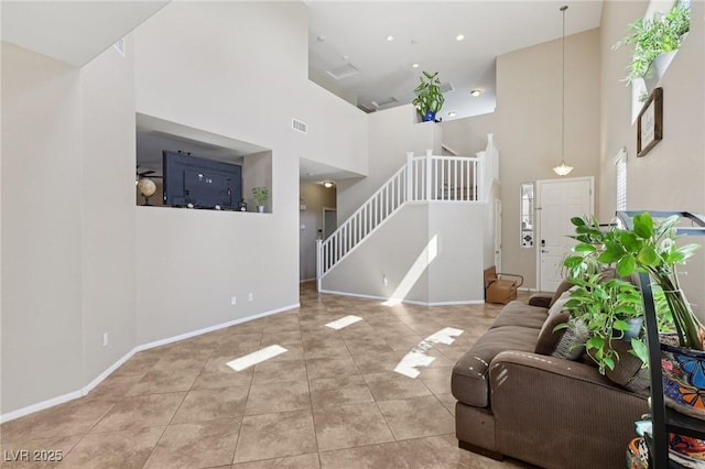10329 Walworth Ave, Las Vegas, NV 89166 - tiled living room featuring a towering ceiling, stairs, and baseboards