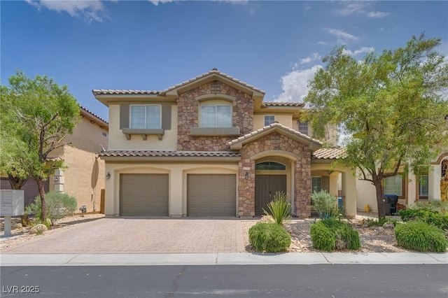 9792 Crescent Lodge Ct, Las Vegas, NV 89178 - mediterranean / spanish-style house featuring a tiled roof, stucco siding, an attached garage, and decorative driveway