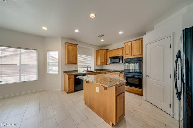 9792 Crescent Lodge Ct, Las Vegas, NV 89178 - kitchen featuring black appliances, a sink, a center island, light stone countertops, and recessed lighting